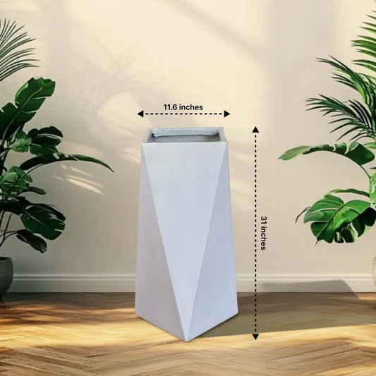 White geometric planter with dimensions labeled, placed on a wooden floor with plants around.