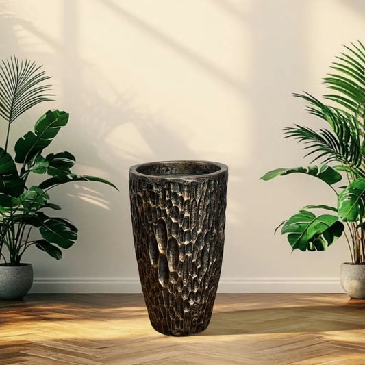 Decorative textured plant pot on a wooden floor with plants on either  black-gold-stone-fiberglass-pot-plantmartpkside.